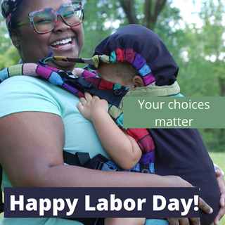 Text reads, "Happy Labor Day! Your choices matter." Photo is of a black mother wearing her daughter in a Carousel of Colors Lenny Upgrade with Mesh panel. Mom is smiling as her daughter pretends to sleep with the hood up