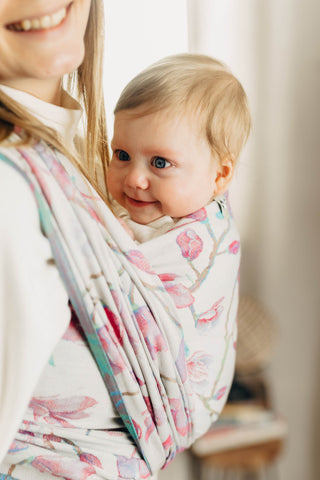 Baby being worn with a long woven wrap in the magnolia design