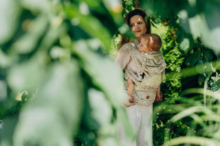 A mom carrying her baby in the LennyLamb Hybrid, Infinity - Golden Hour design. 