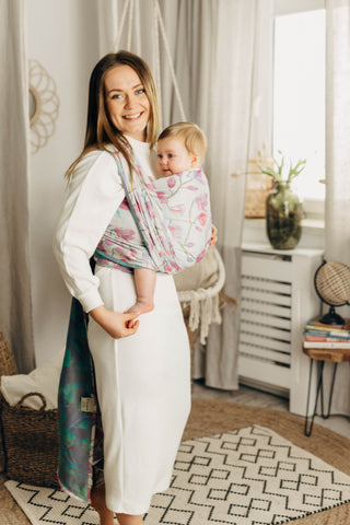 Baby being worn with a long woven wrap in the magnolia design