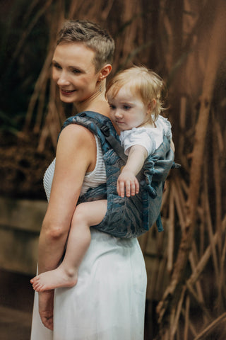 A woman holding her baby on her back with an onbuhimo carrier in the Rainforest Nocturnal Design