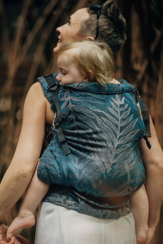 Woman carrying her preschooler in the Rainforest nocturnal preschool carrier