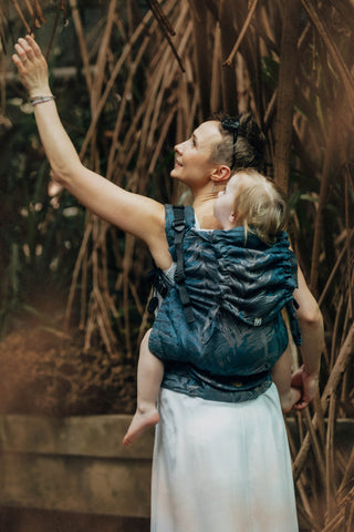 Woman carrying her preschooler in the Rainforest nocturnal preschool carrier